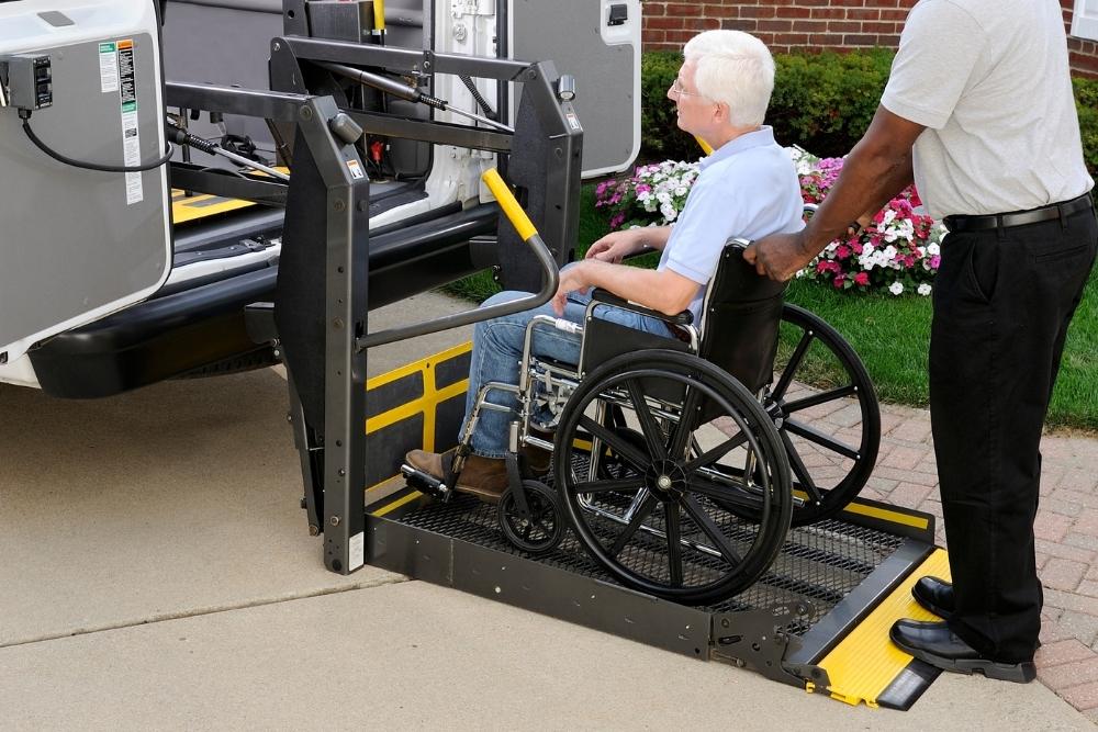 Patient im Rollstuhl mit Transportschein während Krankentransport