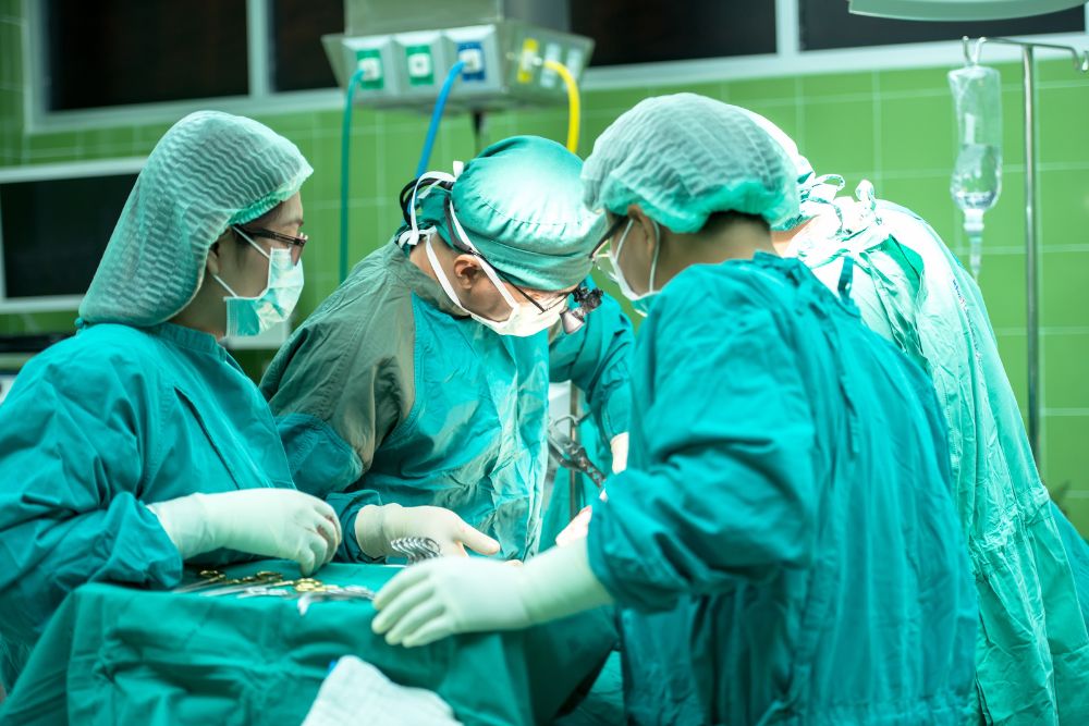 Chirurg und operationstechnische Assistenten in grüner OP-Kleidung