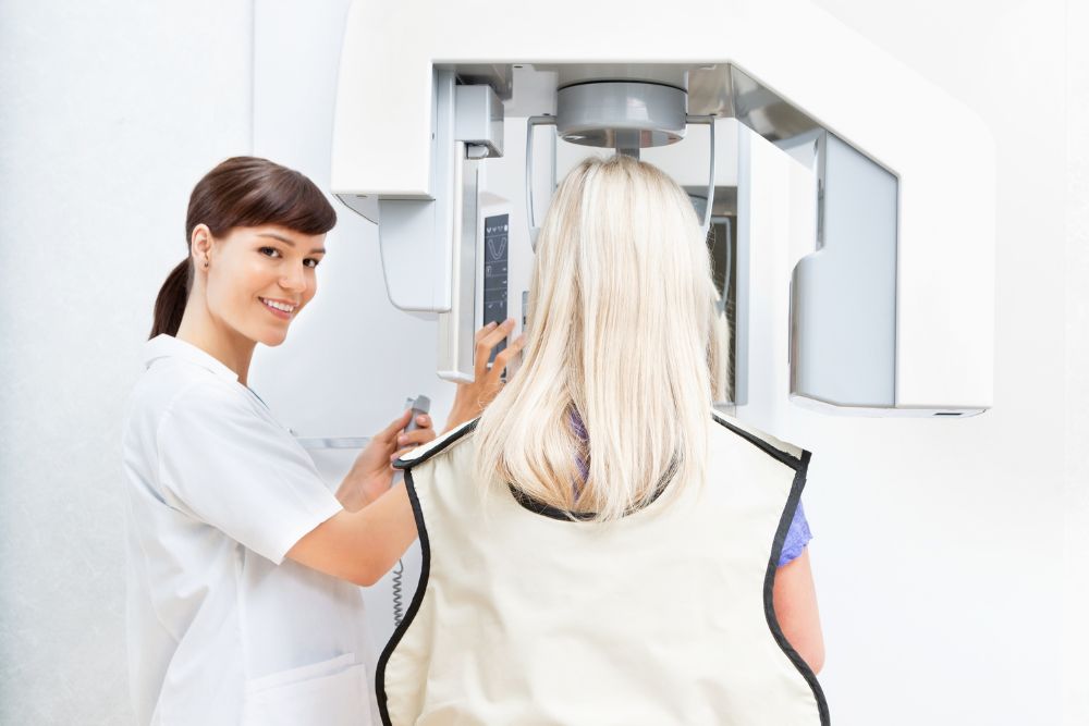 Eine Patientin kurz vor der Orthopantomographie. Die Panoramaschichtaufnahme ist eine zweidimensionale Röntgenaufnahme des Ober- und Unterkiefers.